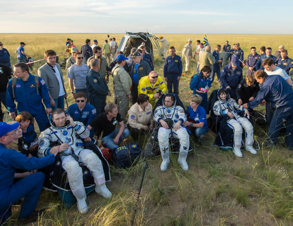 NASA astronaut Terry Virts (left), Russian cosmonaut Anton Shklaperov and Italian astronaut Samantha Cristoforetti sit in chairs outside the Soyuz TMA-15M spacecraft just minutes after they landed in a remote area near the town of Zhezkazgan,