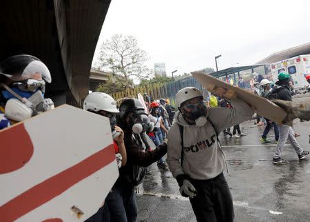 Opposition supporters use homemade shields while clashing with riot police during a rally against President Nicolas Maduro in Caracas, Venezuela May 3, 2017. REUTERS/Carlos Garcia Rawlins