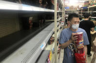 Shelves are empty as residents rush to stock up on necessities at a supermarket after authorities lockdown near residential blocks to prevent the spread of the COVID-19 in Wuhan city in central China's Hubei province Monday, Aug. 2, 2021. Chinese authorities announced Tuesday the mass testing of Wuhan as an unusually wide series of COVID-19 outbreaks reached the city where the disease was first detected in late 2019. (Chinatopix via AP)