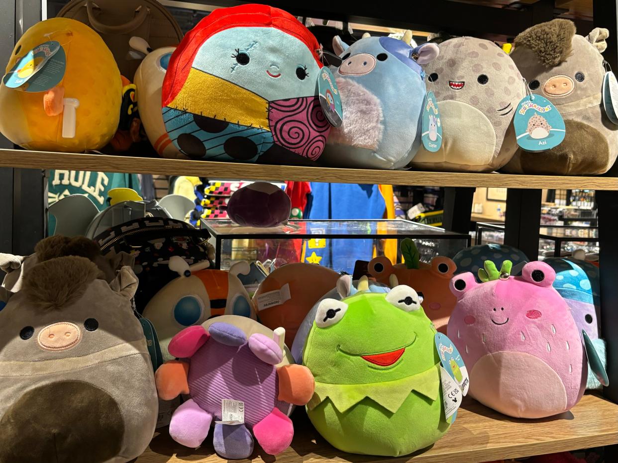 Squishmallows line the shelves of a store.