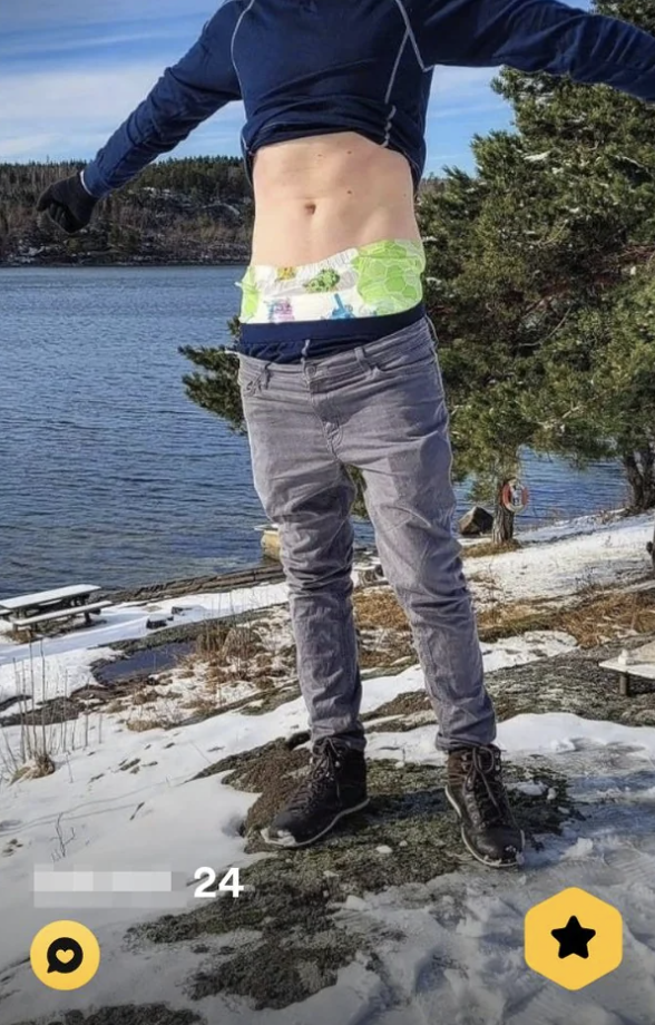 Person jumping, mid-air, obscured face, scenic snowy lakeside background, casual attire