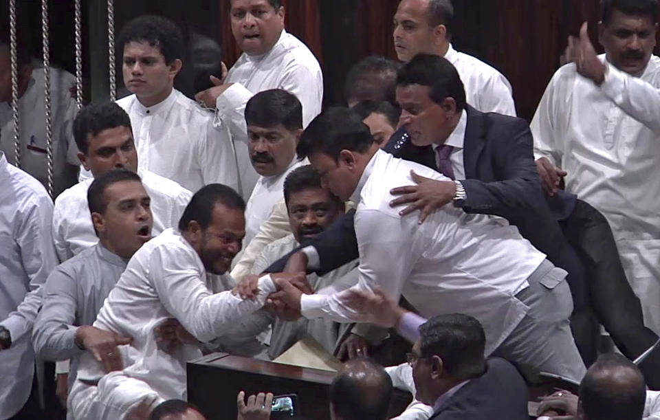 In this image made from video, Sri Lanka's lawmakers scuffle at the parliament in Colombo, Thursday, Nov. 15, 2018. Rival lawmakers have exchanged blows in Sri Lanka's Parliament as the disputed Prime Minister Mahinda Rajapaksa claimed the speaker had no authority to remove him from office by voice vote. (AP Photo)