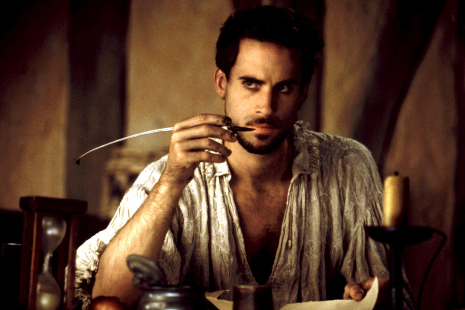 a man holding a quill at his desk