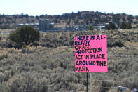 Numerous signs are seen placed along the road leading to Culture National Historical Park in northwestern New Mexico ahead of a visit by U.S. Interior Secretary Deb Haaland on Monday, Nov. 22, 2021. Some Navajo allottee owners are concerned about a proposal to prohibit oil and gas development on federal land holdings within 10 miles of the park, saying it would have significant financial consequences for them. (AP Photo/Susan Montoya Bryan)