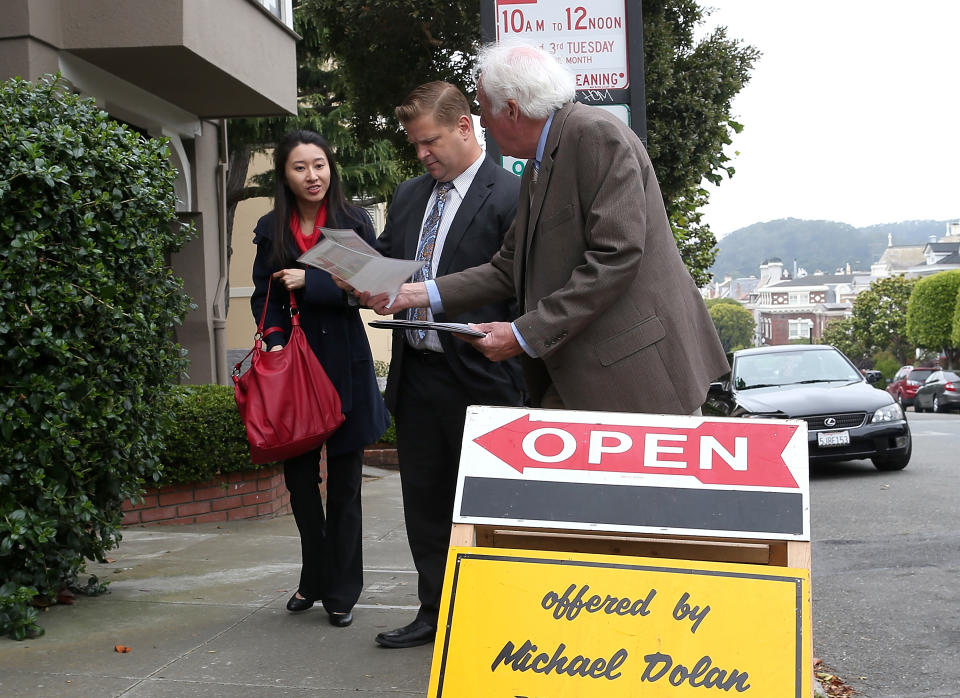 El agente inmobiliario Maurice Dolan distribuye información sobre una casa en venta durante una jornada de puertas abiertas en San Francisco, California.  (Fuente de la imagen: Justin Sullivan, Getty Images)