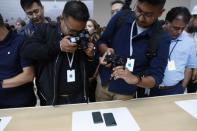 People take photos of new iPhones in the demonstration room at an Apple event at their headquarters in Cupertino