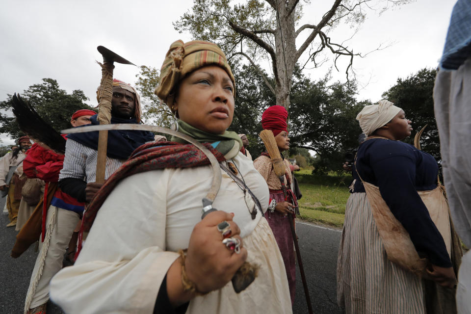 People participate in a performance artwork reenacting the largest slave rebellion in U.S. history in LaPlace, La., Friday, Nov. 8, 2019. The reenactment was conceived by Dread Scott, an artist who often tackles issues of racial oppression and injustice. Scott says that those who took part in the 1811 rebellion were "heroic" and that the rebellion is something that people should know about and be inspired by. (AP Photo/Gerald Herbert)