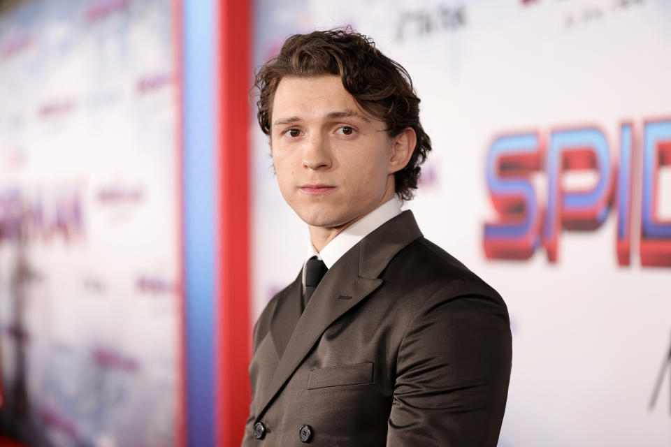 Tom in a tailored suit posing at the "Spider-Man" premiere