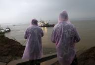 Paramilitary soldiers in raincoats watch a sunken ship and rescue ship in the Jianli section of Yangtze River, Hubei province, China, June 2, 2015. Rescuers fought bad weather on Tuesday as they searched for more than 400 people, many of them elderly Chinese tourists, missing after a cruise boat was buffeted by a freak tornado and capsized on the Yangtze River. (REUTERS/Kim Kyung-Hoon)