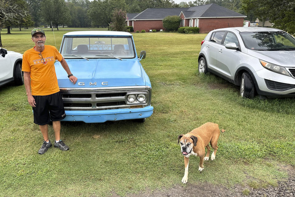 Ricky Dority poses for a photo with his 1969 GMC pickup and his family dog "Boots" outside his family's home in Greenwood, Ark., on Friday, Sept. 22, 2023. Dority was freed from prison this summer with the help of students from Oklahoma City University's Innocence Project. (AP Photo/Sean Murphy)