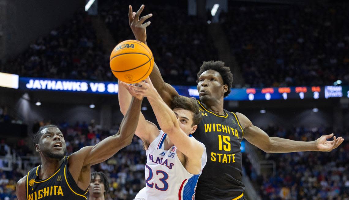 Kansas’ Parker Braun tries to get a handle on a rebound against Wichita State’s Quincy Ballard, right, and Dalen Ridgnal during the second half of their game at the T-Mobile Center on Saturday.