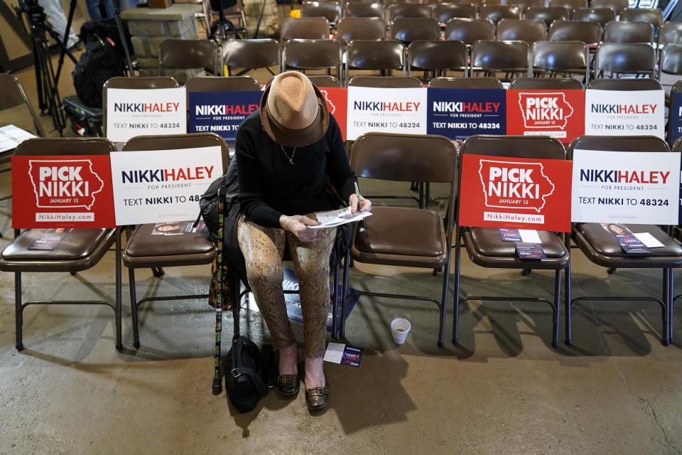 Sandra Sandfort, of Ames, Iowa, signs a commit to caucus card before a Republican presidential candidate Nikki Haley town hall, Monday, Dec. 18, 2023, in Nevada, Iowa. (AP Photo/Charlie Neibergall)