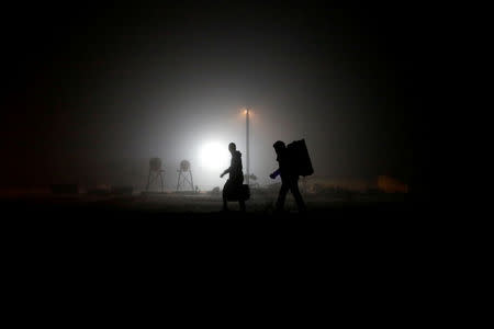 FILE PHOTO: A group of migrants who said they were from Djibouti and Somalia walk along railway tracks after crossing the Canada-U.S. border in Emerson, Manitoba, Canada, March 27, 2017. REUTERS/Chris Wattie/File Photo