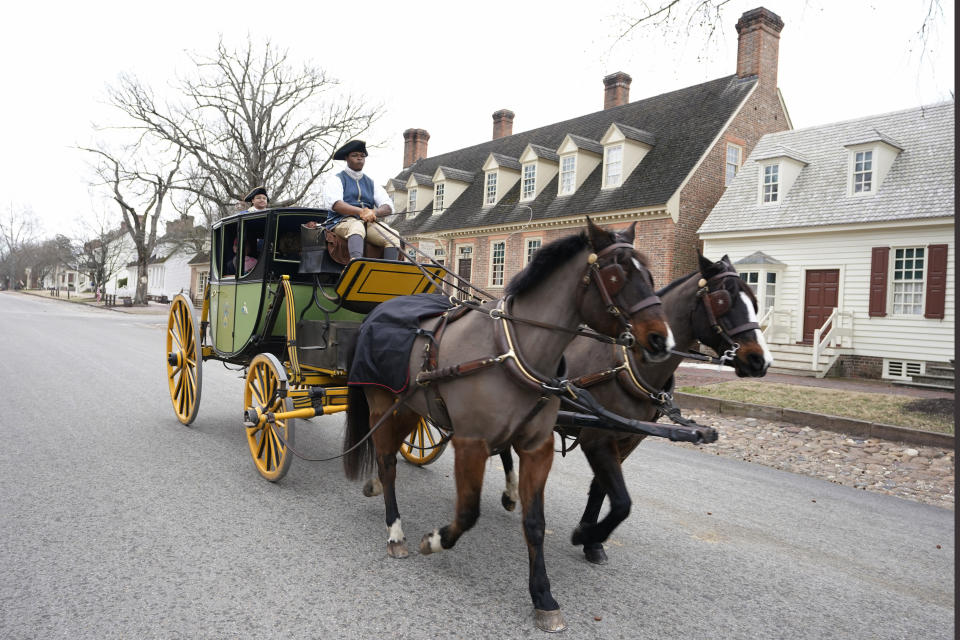 Colonial Williamsburg coachman Collin Ashe drives a coach full of visitors down Duke of Gloucester Street in the restored area Thursday Feb. 24, 2022, in Williamsburg, Va. Colonial Williamsburg has begun to honor the coachmen by naming a new carriage after one of them. (AP Photo/Steve Helber)