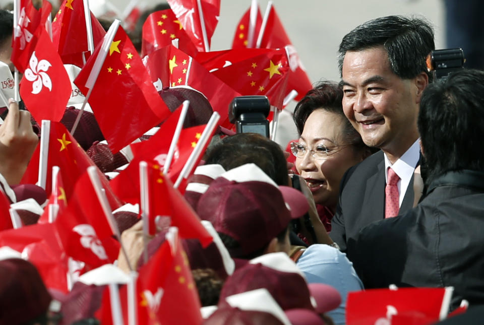 Hong Kong's Chief Executive-elect Leung Chun-ying, right, and his wife Regina shake hands with supporters during a flag raising ceremony to mark the 15th anniversary of Hong Kong's handover to China, Sunday, July 1, 2012, in Hong Kong. Leung was sworn in as Hong Kong's third leader amid growing discontent with China's rule over the Asian financial center. (AP Photo/Kin Cheung)