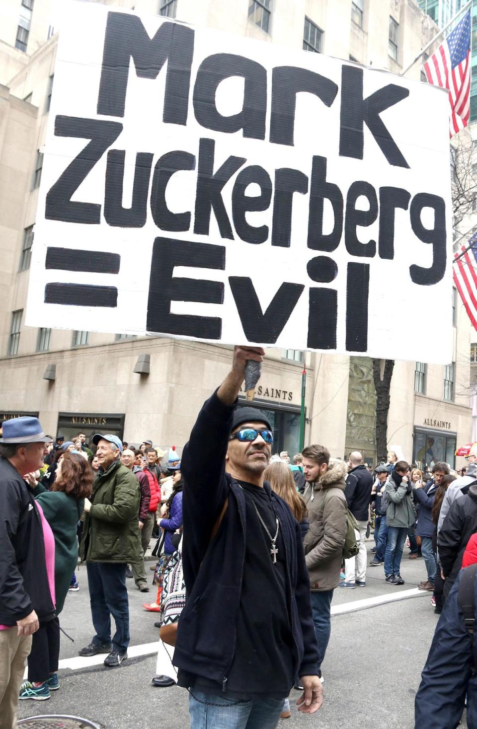 紐約復活節遊行，民眾舉著「祖克柏等於邪惡」的標語，對臉書的數據外洩醜聞表示不滿。（東方IC）