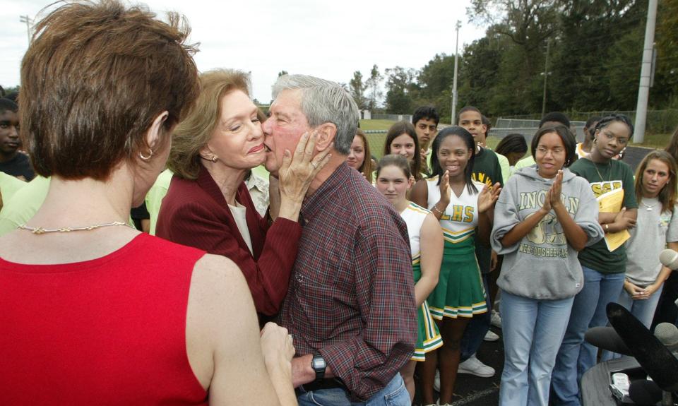 With their oldest daughter, Gwen Logan (L) and students of Lincoln High School watching, Adele Graham pulls husband US Senator Bob Graham in for a closer kiss in 2003 after Graham announced he will not run for a fourth term as U.S. Senator from Florida.