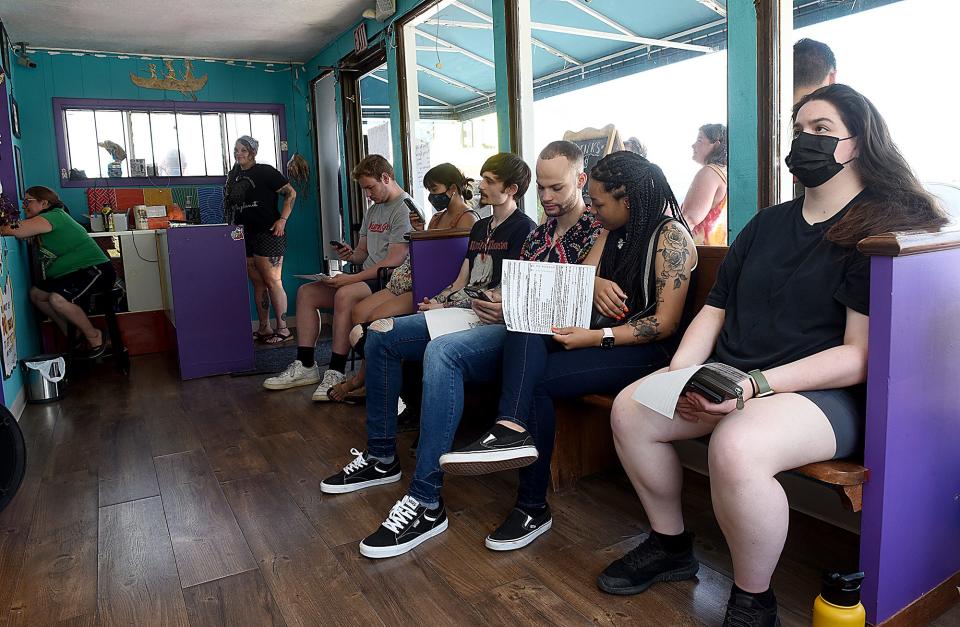 A line of customers stretches from inside The Electric Peacock out the door along the building at 1809 Ammonette St. on Thursday. The tattoo shop is running a half-price tattoo promotion Thursday through Saturday. “It’s a great promotion for us,” shop owner Tyler Hague said.