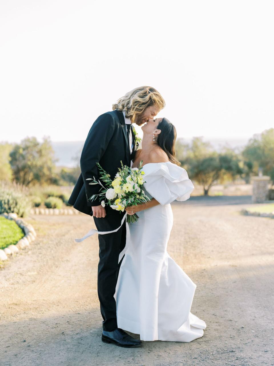 A bride and groom kiss on their wedding day.