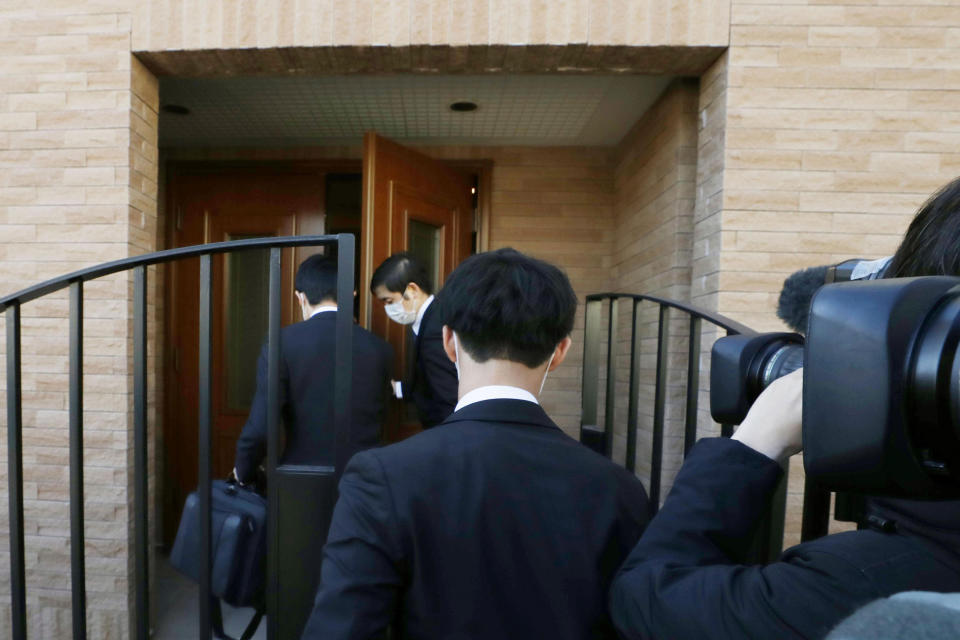 Prosecutors enter former Nissan Chairman Carlos Ghosn's residence during a raid in Tokyo Thursday, Jan. 2, 2020. Japanese prosecutors raided his Tokyo home after he skipped bail and fled to Lebanon before his trial on financial misconduct charges. (Yuki Sato/Kyodo News via AP)