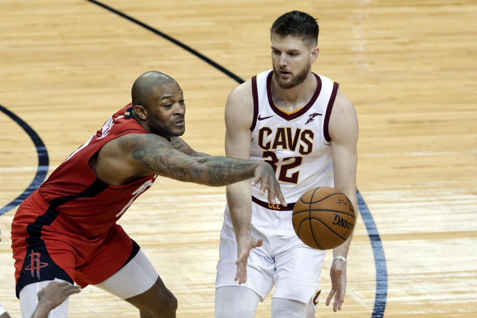 Cleveland Cavaliers forward Dean Wade (32) passes the ball as Houston Rockets forward P.J. Tucker (17) reaches in to knock it away during the first half of an NBA basketball game Monday, March 1, 2021, in Houston. (AP Photo/Michael Wyke)