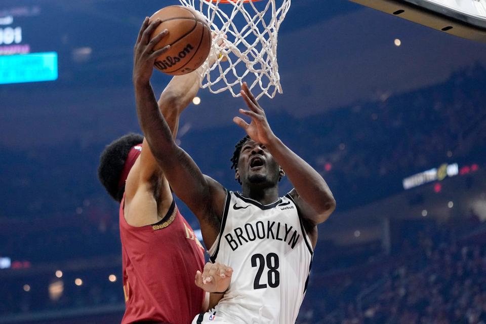 Brooklyn Nets forward Dorian Finney-Smith (28) shoots in front of Cleveland Cavaliers center Jarrett Allen, left, in the first half of an NBA basketball game, Sunday, March 10, 2024, in Cleveland. (AP Photo/Sue Ogrocki)