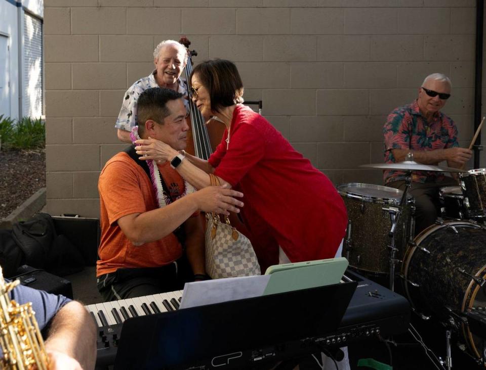 The Martini Crush band performed before the Sloppy Moose Running Club 3 mile run that began and ended at Bike Dog Brewing Company in West Sacramento on June 20, 2024. Piano player Chris Lee is embraced by his mother Sharon Lee after his friends sang happy birthday to him.