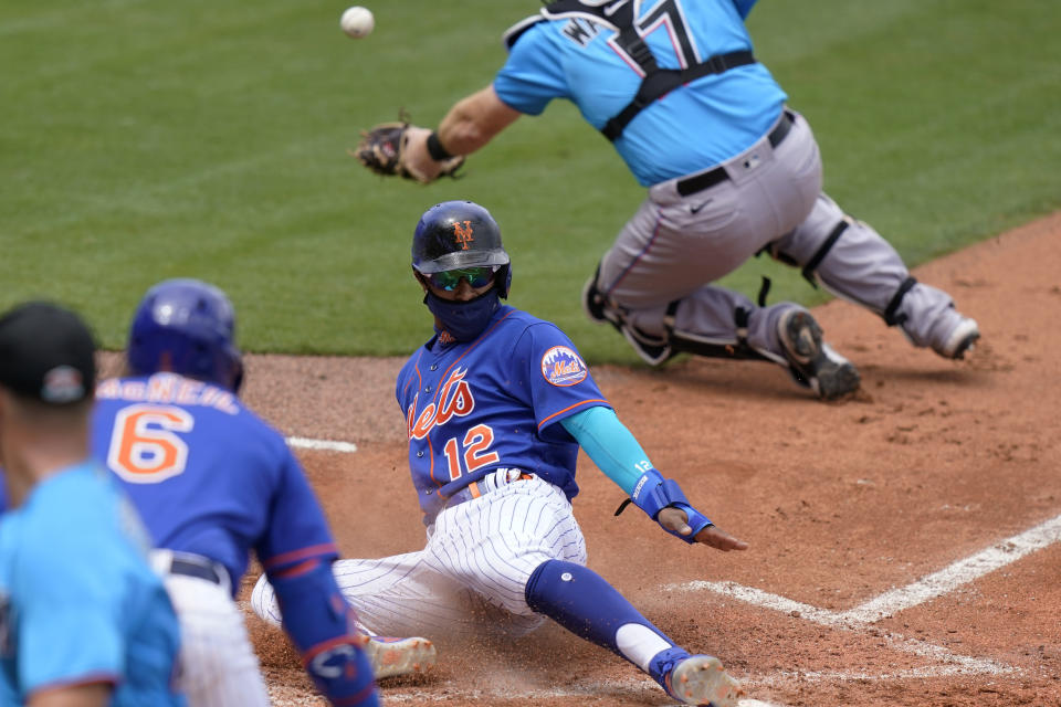 New York Mets' Francisco Lindor (12) beats the throw to Miami Marlins catcher Chad Wallach (17) to score on an error during the third inning of a spring training baseball game, Tuesday, March 23, 2021, in Port St. Lucie, Fla. (AP Photo/Lynne Sladky)