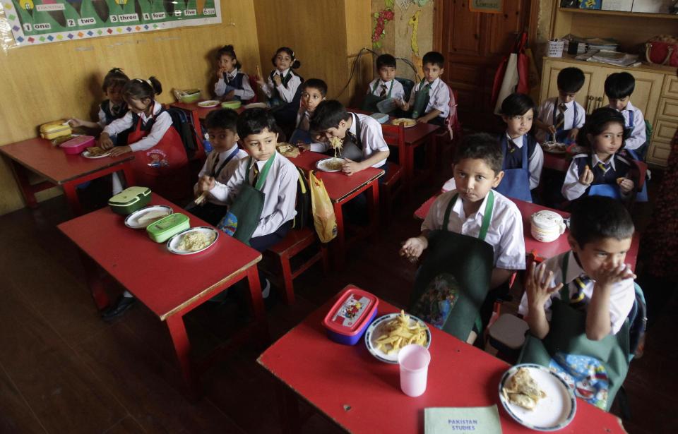 Students eat their lunch at the Bahria Foundation school in Rawalpindi, Pakistan, Tuesday, May 6, 2014. Most of the children at the school have home cooked food for lunch, which contain eggs, chicken nuggets, bread, rice or noodles. Some have vegetables, minced mutton or beef prepared and cooked at home the night before. Principal Syeda Arifa Mohsin says the school tries to dissuade parents from fixing junk food for their children. (AP Photo/Anjum Naveed)
