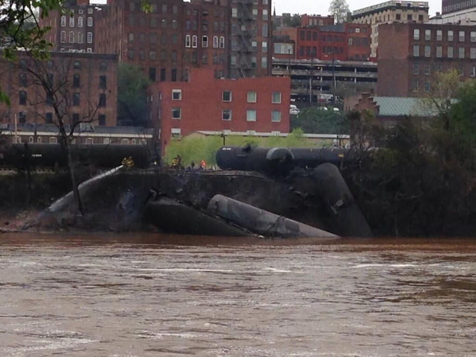 Emergency personnel attend to a CSX Corp train carrying crude oil that derailed and burst into flames in downtown Lynchburg, Virginia, April 30, 2014. (REUTERS/WSET/Handout via Reuters)