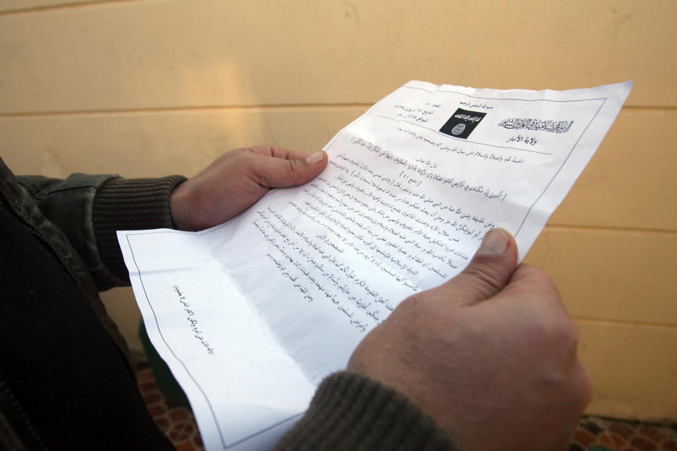 A man reads a pamphlet issued by al-Qaida-linked militants in Fallujah, Iraq, Thursday, Jan. 16, 2014. Members of al-Qaida's local franchise handed out pamphlets urging residents in the western city of Fallujah to take up arms and back the militants in their weeks-long fight against Iraqi troops as clashes raged on around the city, residents said Thursday. (AP Photo)