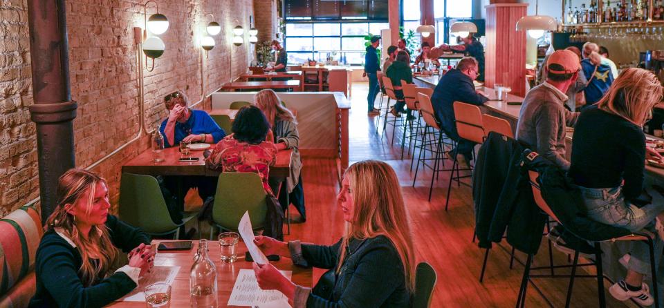 Cailin Mahoney, left front, and Susan Speidell look over the menu during a business dinner at Bavette la Boucherie's new location, 217 N. Broadway.