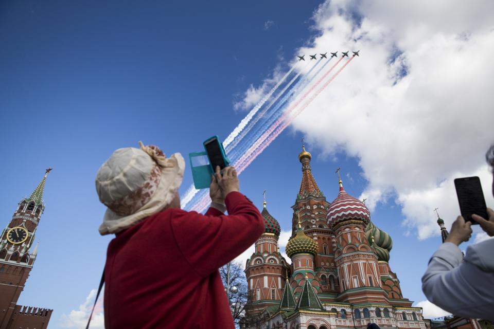 <p>Tourists takes photos of Russian jets flying over the Kremlin during a rehearsal for the Victory Day military parade. (AP Photo/Pavel Golovkin) </p>