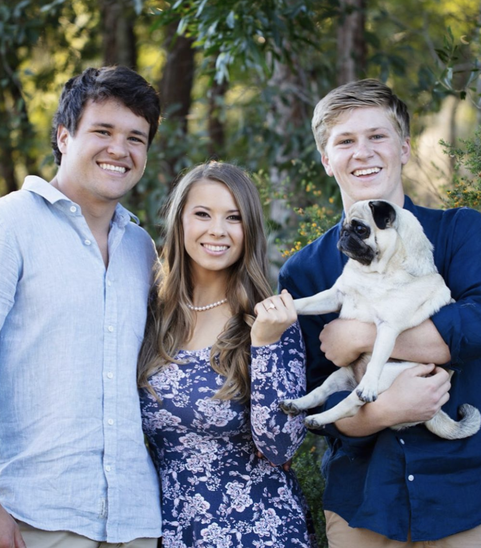 Bindi Irwin, Chandler Powell, Robert Irwin and Stella the pug pose for a photo after Bindi and Chandler's engagement announcement.