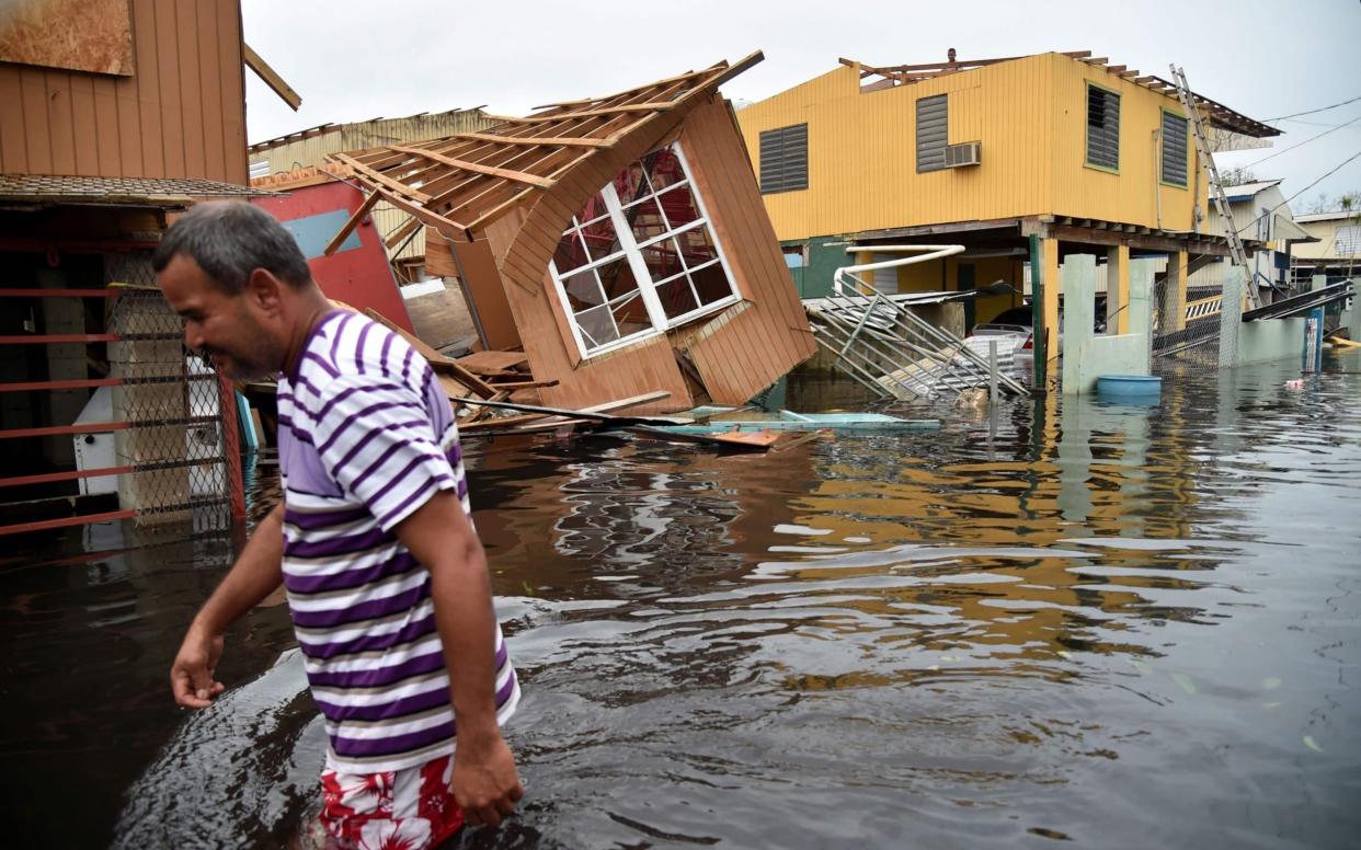 A man walks past destroyed homes in Catano, Puerto Rico, on September 21, 2017 - AFP