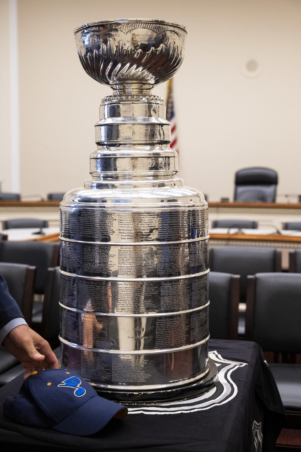 A man puts down a St. Louis Blues hat as the Stanley Cup is on display in the Rayburn Office Building