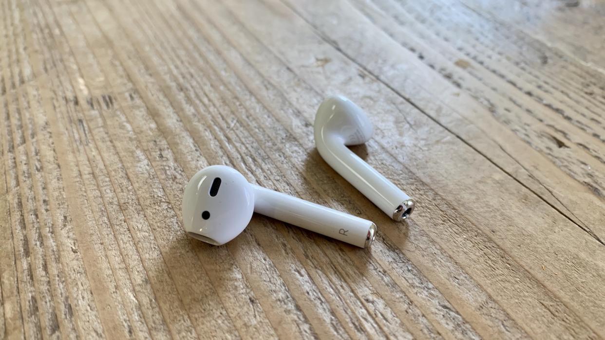  Apple AirPods on a wooden table . 