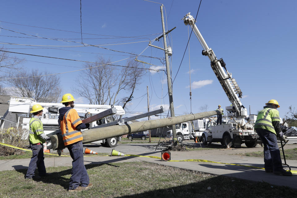 Electrical workers install a new power line poll Friday, March 6, 2020, in Nashville, Tenn. Residents and businesses face a huge cleanup effort after tornadoes hit the state Tuesday. (AP Photo/Mark Humphrey)