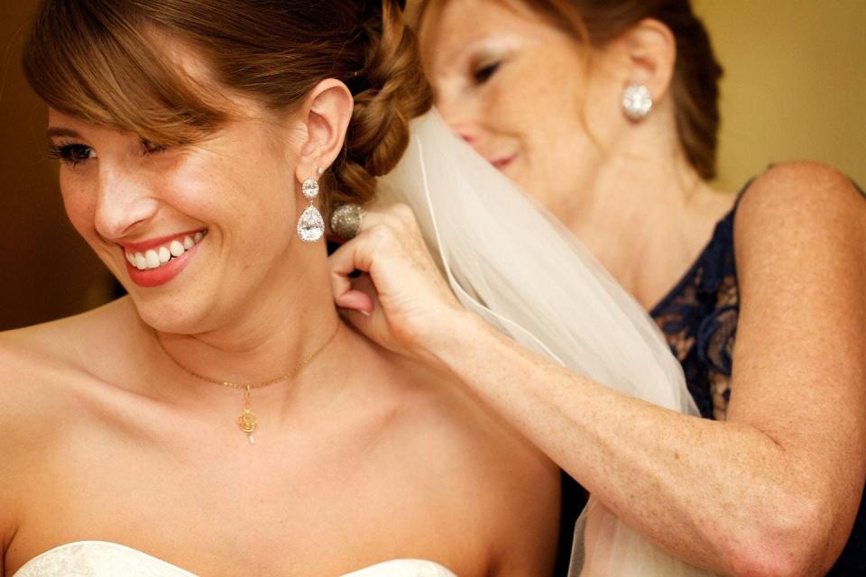 Karen Johnson helps her daughter, Katelyn Johnson Reed, with the family heirloom necklace. Five generations of women in their family have worn the necklace at their weddings.