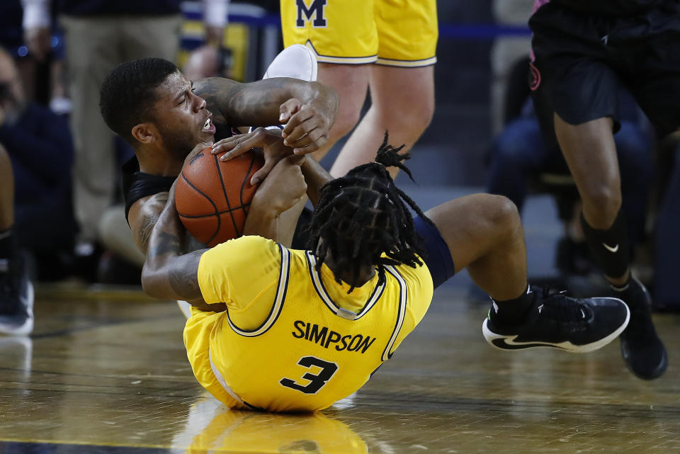 Michigan guard Zavier Simpson (3) and Penn State guard Myles Dread (2) battle for a loose ball in the first half of an NCAA college basketball game in Ann Arbor, Mich., Wednesday, Jan. 22, 2020. (AP Photo/Paul Sancya)