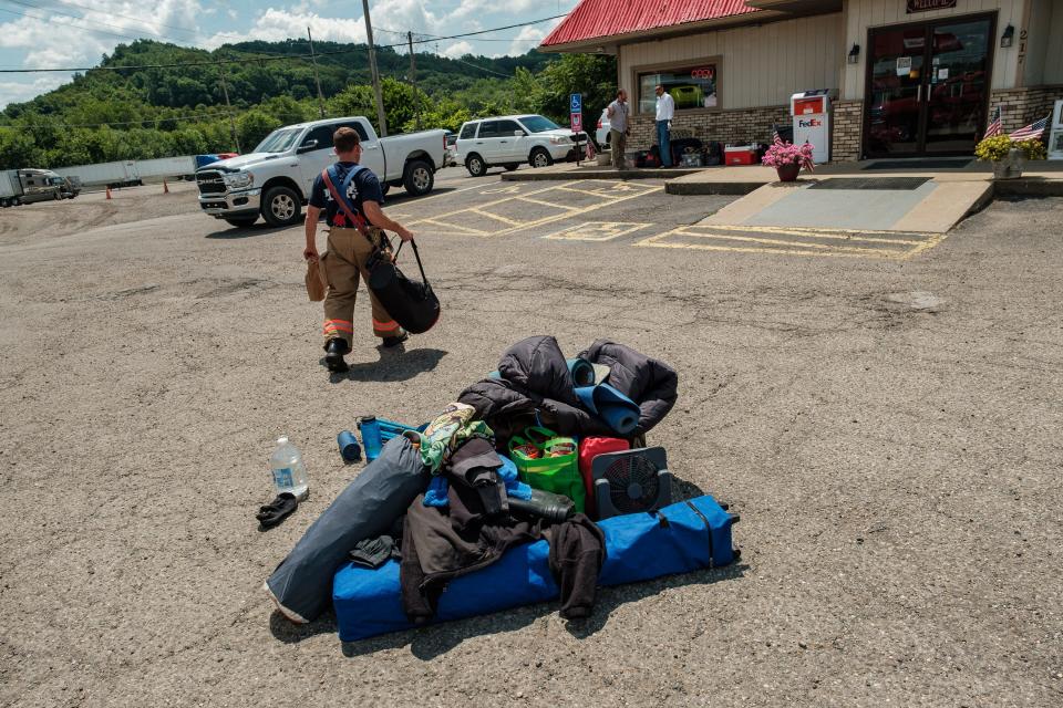 Captain Matthew Graham of the New Philadelphia Fire Department helps to move the contents of a vehicle that caught fire and was subsequently extinguished in the parking lot of the Eagle Truck Stop, Tuesday, July 11 in New Philadelphia.