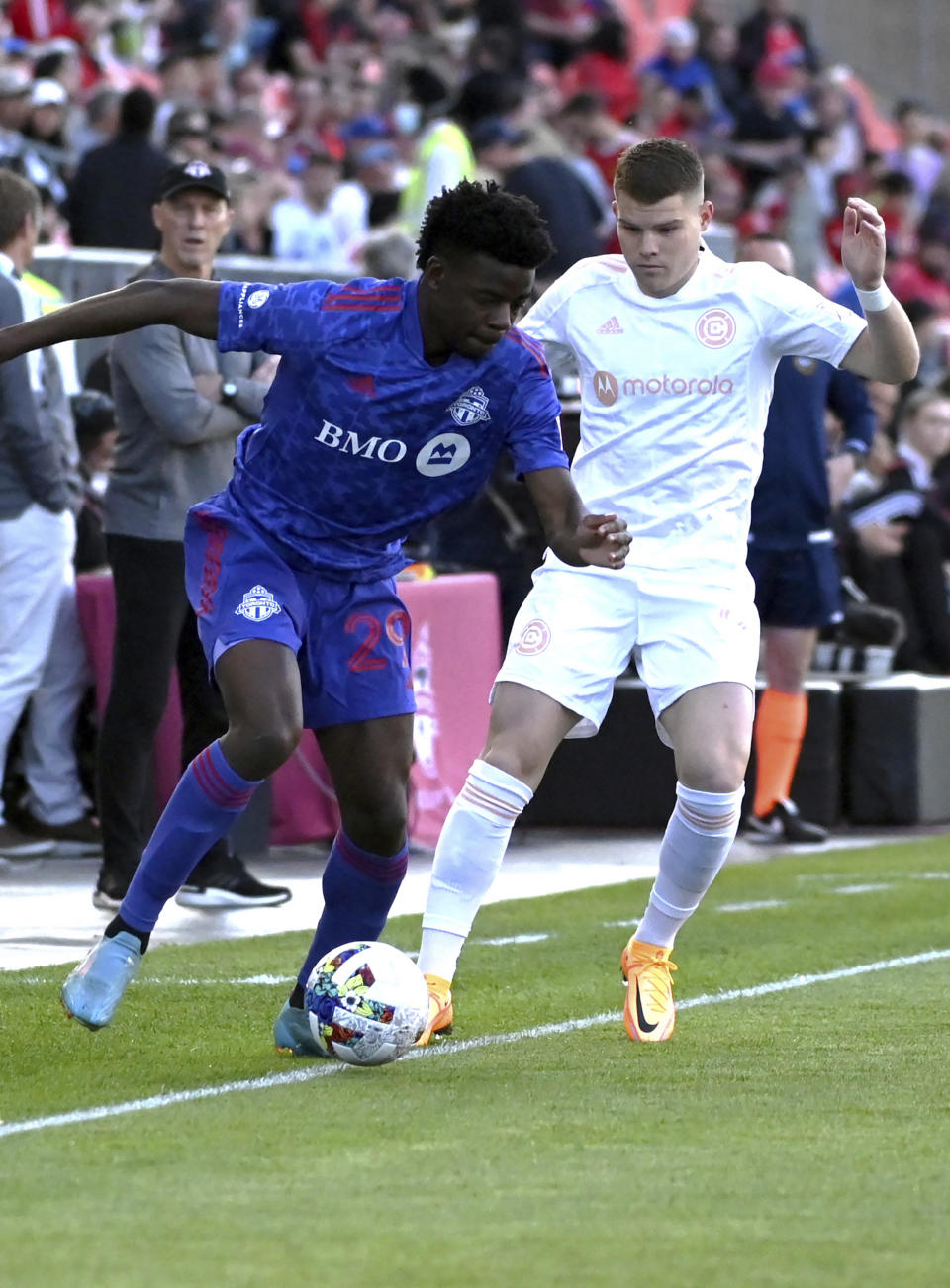 Toronto FC's Deandre Kerr, left, vies for possession of the ball against Chicago Fire's Chris Mueller during the first half of an MLS soccer match Saturday, May 28, 2022, in Toronto. (Jon Blacker/The Canadian Press via AP)