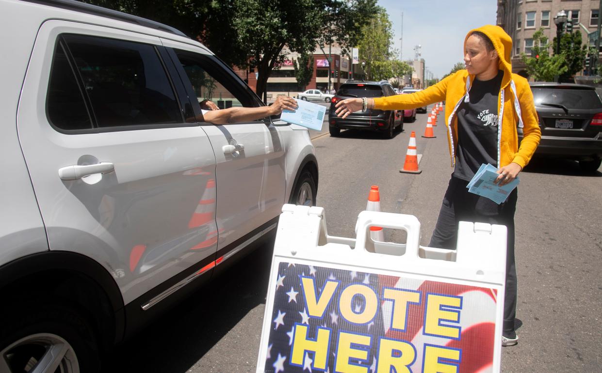 Election worker Kymra King accepts a ballot from a motorist at the drive-up ballot drop-off location outside of the San Joaquin County Administration Building on San Joaquin Street and Weber Avenue in downtown Stockton on June 7, 2022.