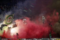 Augsburg fans set off pyrotechnics during the German Bundesliga soccer match between Eintracht Frankfurt and FC Augsburg in Frankfurt, Germany, Friday, April 19, 2024. (Arne Dedert/dpa via AP)