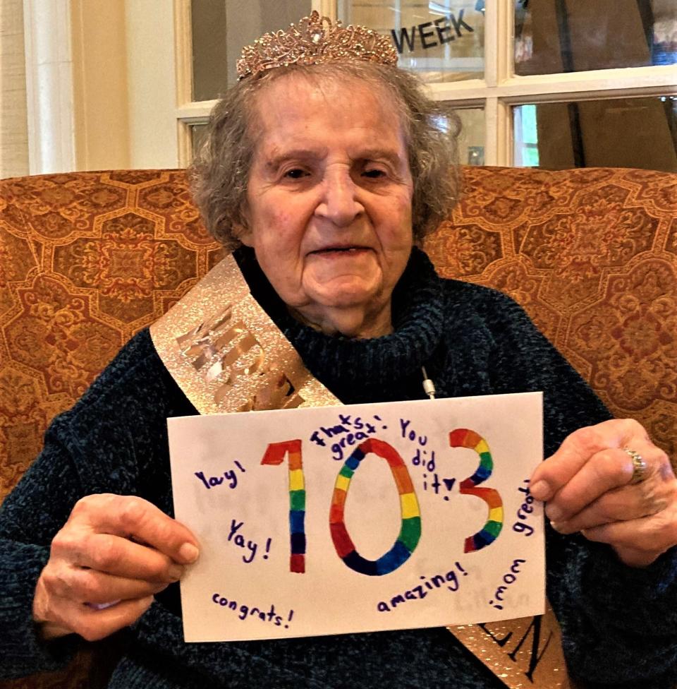 Lillian Etkind, a resident of Sunrise Senior Living in Cohasset, holds one of the 103 cards that Cohasset's Deer Hill School students made for her 103rd birthday Monday, May 23, 2022.