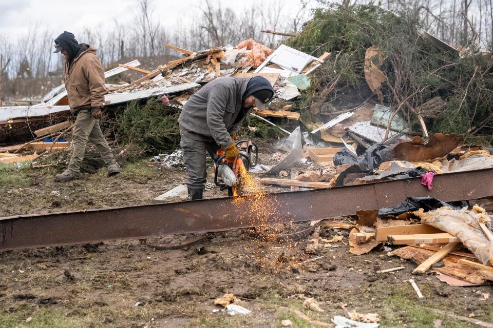 Mar 18, 2024; Lakeview, Ohio, USA; Volunteers and employees of the Foster Equipment Sales company out of Springfield, Ohio help to clean up debris in the Geiger Mobile Home Park. Two residents of the Park died when homes were destroyed during a tornado that swept through the area.