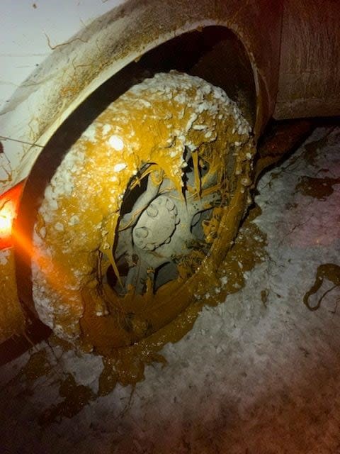 The tires of a RCMP vehicle that went into the ditch Thursday following a highway spill appears caked with oily sludge.  (Alberta RCMP - image credit)