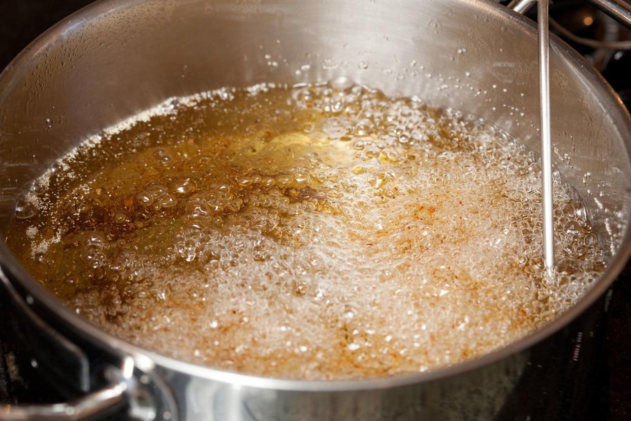 pouring oil into pot to fry