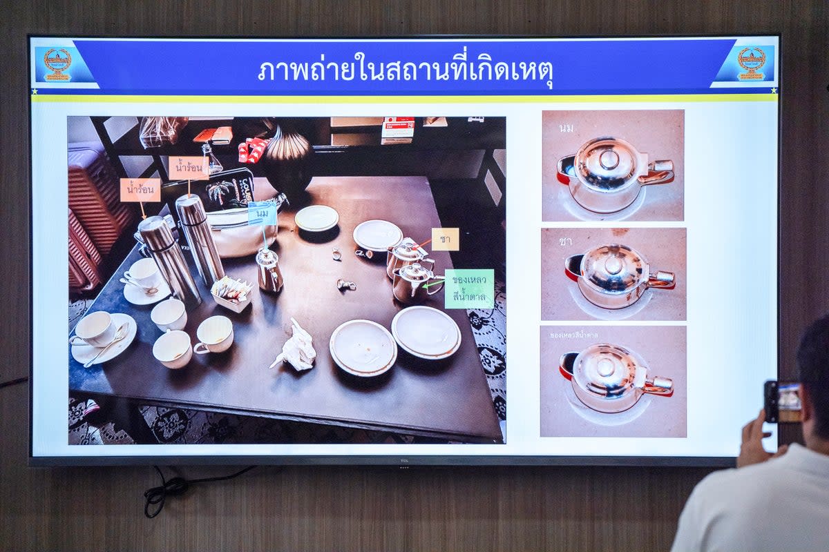 Members of the media view images of drinks left in the room where six people were found dead (Getty)