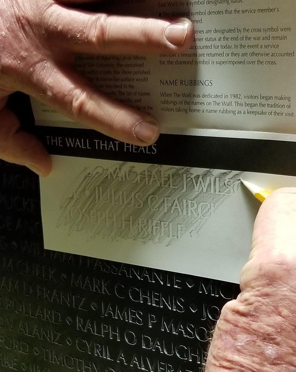 A visitor to The Wall That Heals makes a rubbing of a name from the replica of the Vietnam Veterans Memorial in this undated photo.